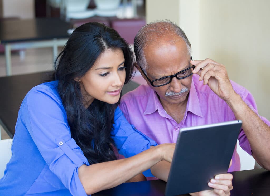Man and daughter looking at device screen