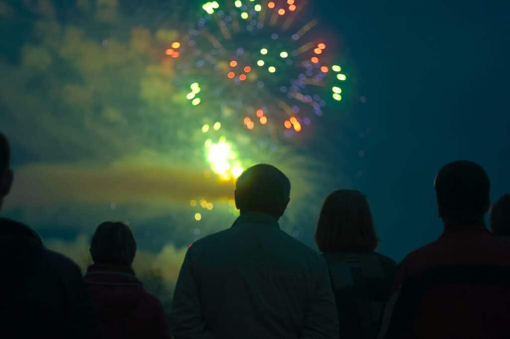 Person looking up at fireworks at night